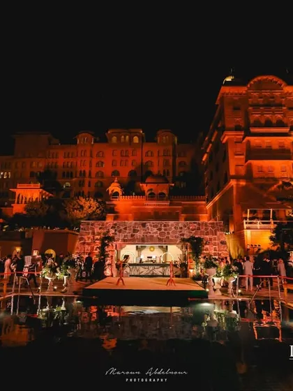 A stunning view of the welcome dinner setup over a pool. The reflection of the lights on the water, combined with the regal architecture, created a truly breathtaking scene.