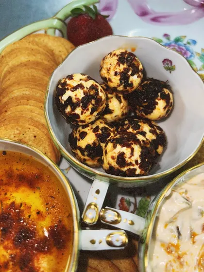 A close-up of our chili-dusted cheese balls, served in an elegant teacup as part of a custom platter. We love working with clients to create unique presentations.