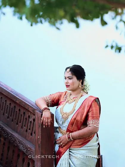 An elegant bridal portrait of a woman in a beautiful saree, posing on a grand staircase.