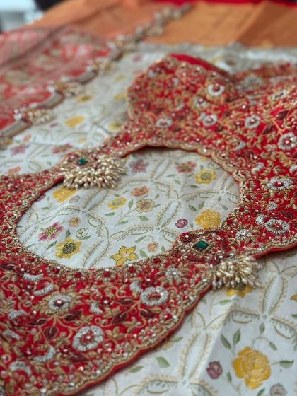 The back cutout of the red blouse is heavily embroidered with zardosi and stones.