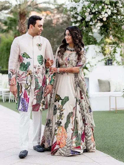 For Devangi and Aakash's Sangeet, we celebrated their story with custom floral-printed ensembles. This look captures them in a moment of pastel perfection, with coordinated outfits that feel both romantic and vibrant. Our work extends to the family, ensuring everyone's attire complements the theme, creating a picture of love and unity.