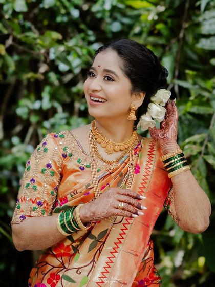 A happy Maharashtrian bride, her smile as bright as her beautiful Paithani saree.