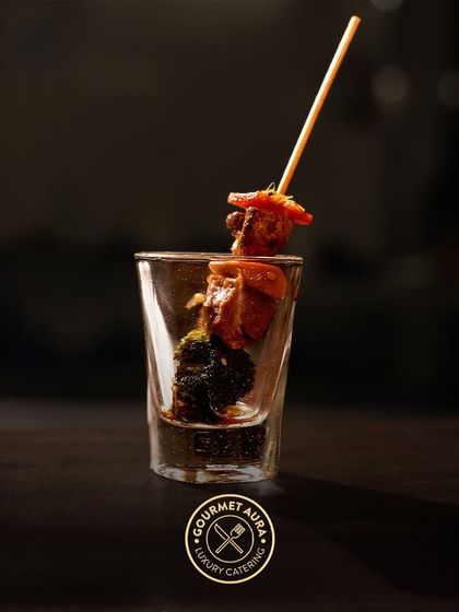 A single skewer with grilled chicken and broccoli presented in a shot glass. A stylish and convenient way to serve delicious appetizers.