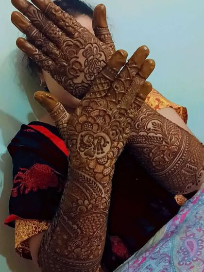 A stunning engagement mehndi. The design includes the couple's initials hidden within a floral crest, a personal touch for the bride-to-be.