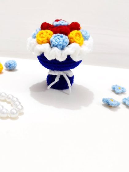 A special Snow White themed mini bouquet keychain, using her signature colors of red, yellow, and blue.