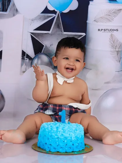 The pure joy of a first birthday is captured in this cake smash session. This little boy's infectious laugh and messy hands are the perfect representation of a milestone celebrated with fun and sweetness.