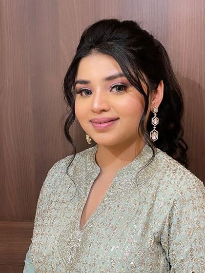 This client is ready for a celebration with her soft, wavy half-updo and glowing makeup. It's a perfect look for any festive event.