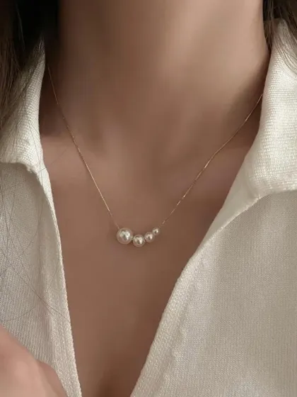 A simple and classic piece for everyday elegance. This delicate necklace features a series of graduating pearls on a fine, gold-tone stainless steel chain, perfect for wearing to university or work.