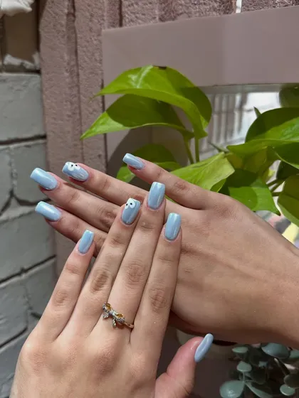 Simple, sweet, and chic. A lovely powder blue manicure with a delicate, hand-painted daisy accent nail.