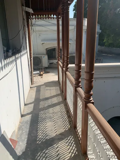 The finished balcony, with its intricate wooden railing casting beautiful shadows in the afternoon sun.