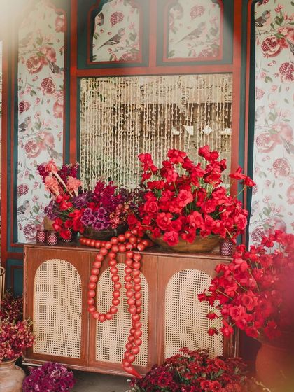 The decor featured rich textures and patterns, with red flowers spilling out of cabinets and traditional Indian motifs on the walls.