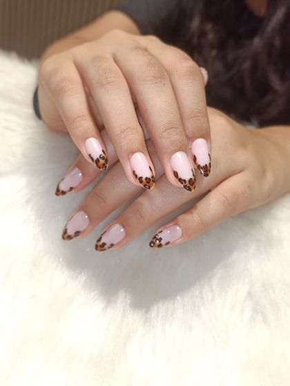 Another view of the leopard print French tips, showing the consistency of the hand-painted pattern across all nails.