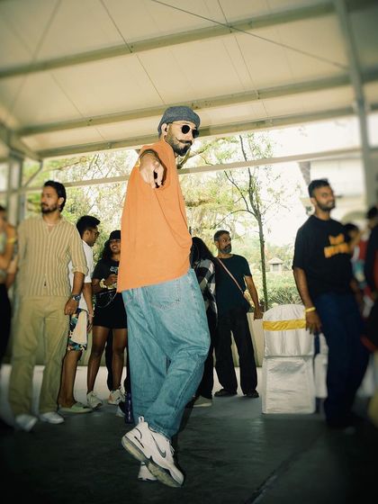 A candid shot from a dance event, pointing to the next dancer up. The cypher is about sharing space and giving everyone a chance to express themselves.