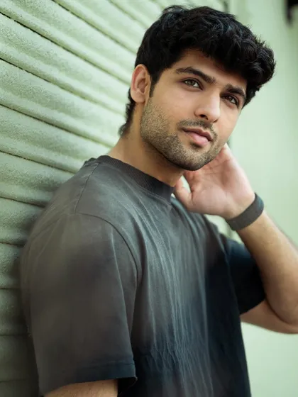 A close-up portrait with an urban feel, using a shutter door as a textured background. This shot focuses on the model's expression and features, perfect for a casting headshot.