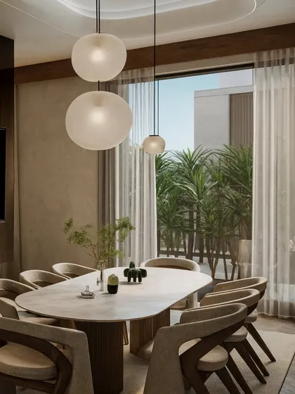 The dining area adjacent to the lounge continues the warm, sophisticated feel with an oval dining table and sculptural chairs. Large glass doors connect the space to an outdoor garden, blurring the lines between inside and out.