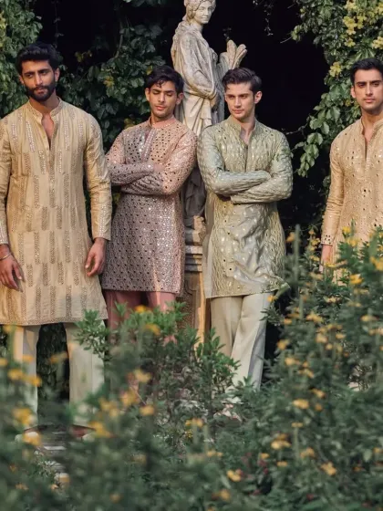 A group of groomsmen wearing my custom mirror-work kurtas in a variety of pastel shades like beige, pink, and sage green. I can create coordinated yet unique looks for your entire wedding party.