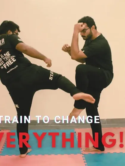 We train to change everything. This action shot shows two of our instructors practicing kicking and blocking drills, a fundamental part of building reflexes and muscle memory for unarmed combat.