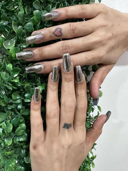 A full set of long, square-tipped silver chrome nails for a futuristic and edgy look.