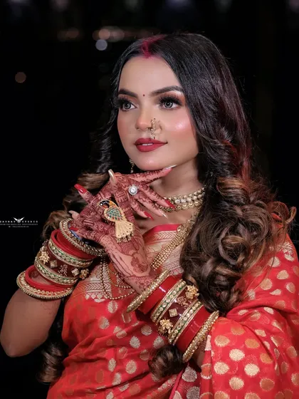 A close-up on the model's hands, showcasing the intricate henna design and traditional bangles.