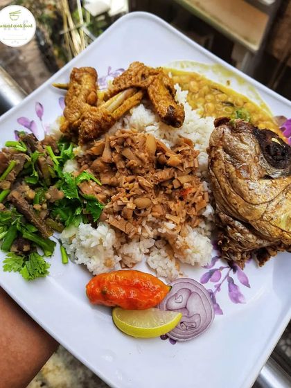 A platter full of favorites: baby bamboo shoot singju, banana flower eromba, a fried fish head, and chicken wings.