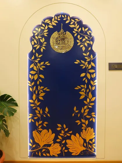 We highlighted this entrance wall with a classical arch and enhanced it with beautiful gold leafing art on a vibrant Prussian blue niche.