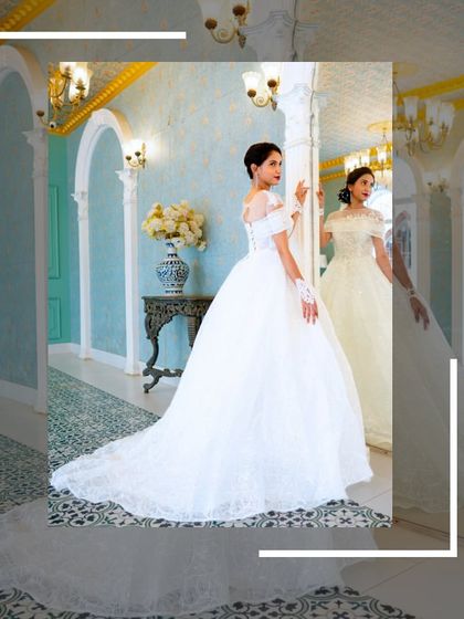 A full-length shot of the white Catholic gown, capturing its grandeur as the bride looks into a mirror.