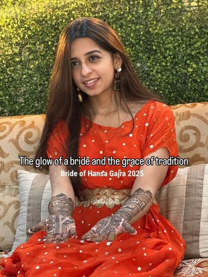 The glow of a bride and the grace of tradition. A beautiful portrait of a bride-to-be, her orange outfit and intricate mehendi creating a vibrant and joyful look.