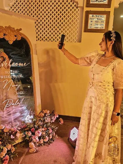 A selfie in a mirror welcome sign at a wedding for Nirav and Palak. This kind of personalized and elegant detail is a hallmark of the destination weddings I plan, creating picture-perfect moments for everyone.