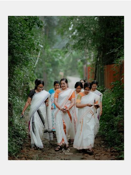 The bride and her entourage walking down a path, a beautiful and candid moment from the pre-wedding festivities.
