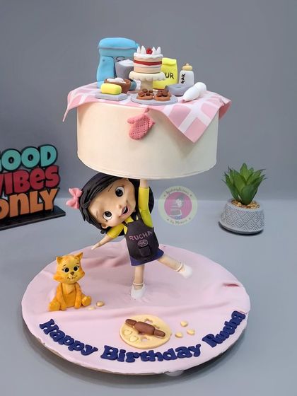 This baking-themed anti-gravity cake was a joy to create. A little baker figurine holds up a floating tier filled with miniature baking tools, all handcrafted from fondant.