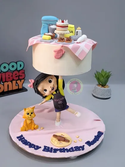 This baking-themed anti-gravity cake was a joy to create. A little baker figurine holds up a floating tier filled with miniature baking tools, all handcrafted from fondant.