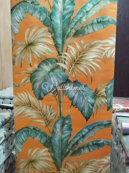 This vibrant tropical leaf wallpaper, shown here unrolled, is perfect for creating a bold and lively accent wall. The bright orange background and lush green foliage bring a touch of nature indoors.