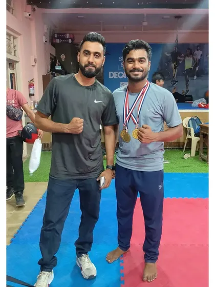 A coach congratulates his athlete on winning four gold medals. This personal guidance is crucial for developing top-tier competitors.