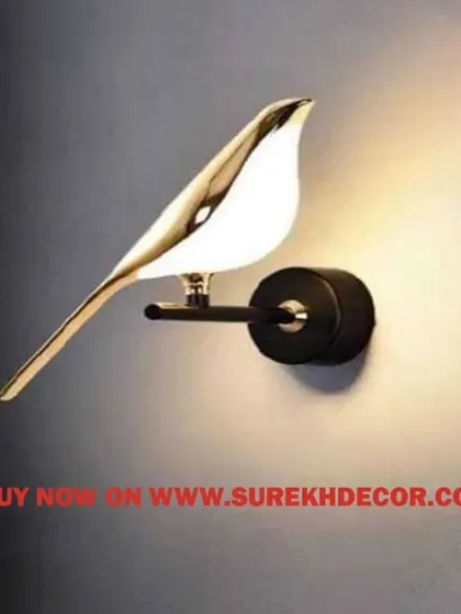 This antique chirpy wall lamp is designed in the shape of a bird with a golden finish. The body of the bird glows with LED light, creating a whimsical and artistic accent piece for any wall.