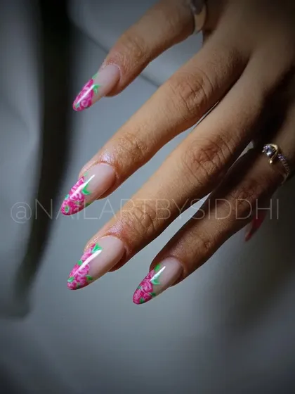 A full set of stiletto nails with a French tip border of hand-painted roses.