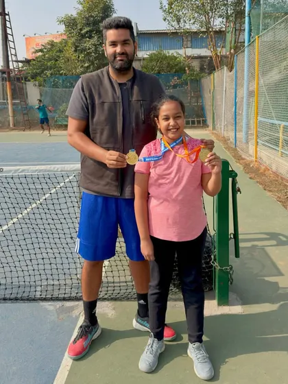 Pratyaksha Singhal showing her two medals from her school tennis tournament at Kothari International School, where she won both the Under-11 and Under-13 categories. We are very happy with her progress.