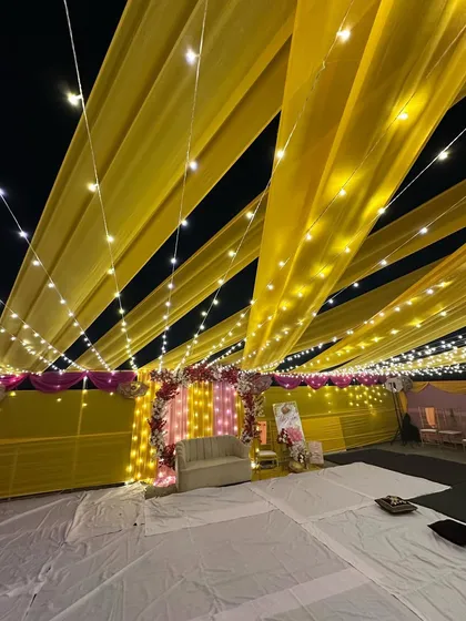 We can turn any space into a celebration zone, even a terrace. Here's a full view of a vibrant Haldi ceremony setup, where we used bright yellow drapes and thousands of fairy lights to create a festive canopy under the night sky.