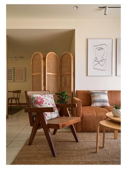 A closer look at the living space, focusing on the handcrafted wooden armchair with woven cane details. This piece exemplifies our commitment to bespoke solutions that blend traditional craftsmanship with modern comfort.