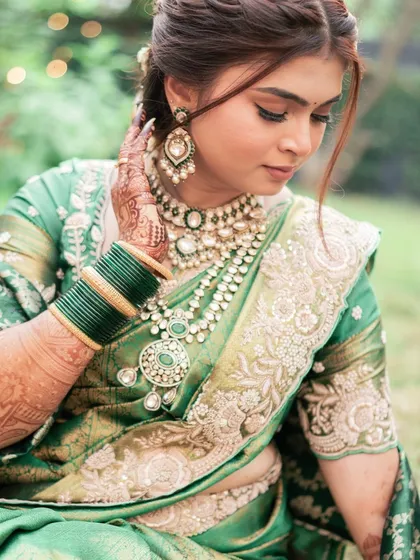 A close-up on the beautiful details. The soft eye makeup and perfectly blended skin look stunning with the intricate embroidery of her saree and the traditional jewelry.