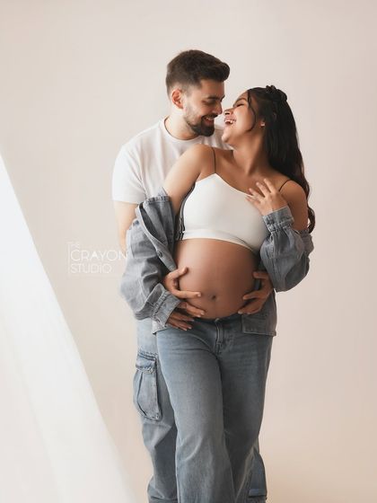 An intimate embrace, noses touching, full of smiles. This close up shot captures the pure joy and love between the expectant parents.