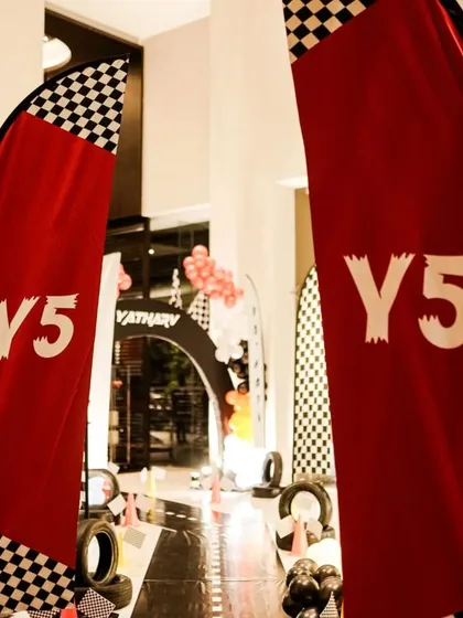 Custom racing flags mark the entrance to an action-packed 5th birthday party. This detail immediately sets the tone for a fun, race-themed celebration.