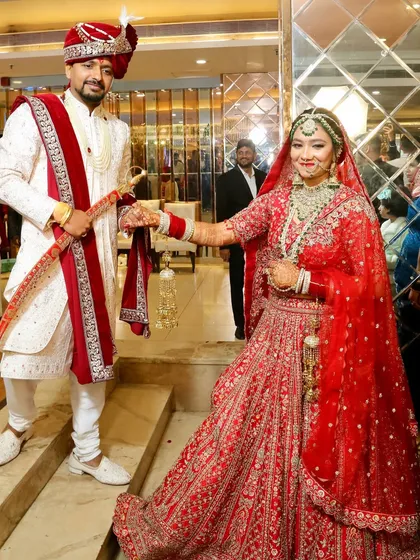 Getting my childhood friend ready for her wedding was such an emotional moment. Here she is with her groom, looking absolutely radiant in a classic red lehenga.
