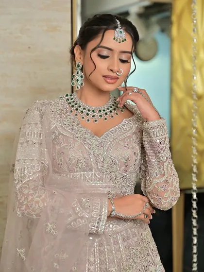 A graceful pose highlighting the full sleeve details of the blouse and the complete jewellery set, including the hathphool.