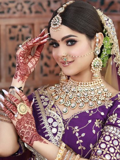 A close-up of the bride in the purple lehenga, showing her intricate henna and the flawless makeup that complements her modern outfit.
