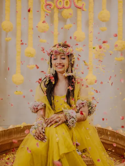 A serene portrait of the bride amidst a shower of petals, her eyes closed and a gentle smile on her face, enjoying the moment.