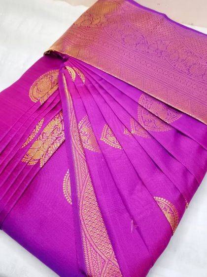 A vibrant purple saree with gold motifs. The pleats are set perfectly, ensuring a beautiful drape every time.