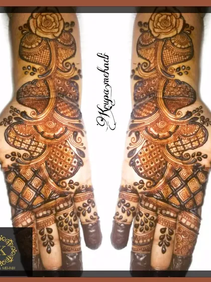A classic Arabic mehndi concept. The design flows diagonally across the hands, featuring bold floral and paisley patterns that are characteristic of this style.