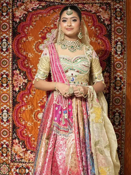 Embrace vibrant traditions with this multi-colored bridal lehenga. The combination of gold, pink, and rich fabrics, paired with a complete Kundan jewellery set, makes it a perfect choice for a bride who loves color and grandeur.
