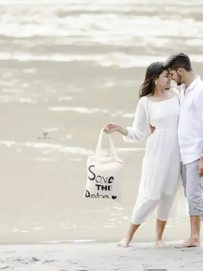 A sweet "Save the Date" photo on the beach, with the couple holding a custom tote bag. It's a creative and personal way to share their news.