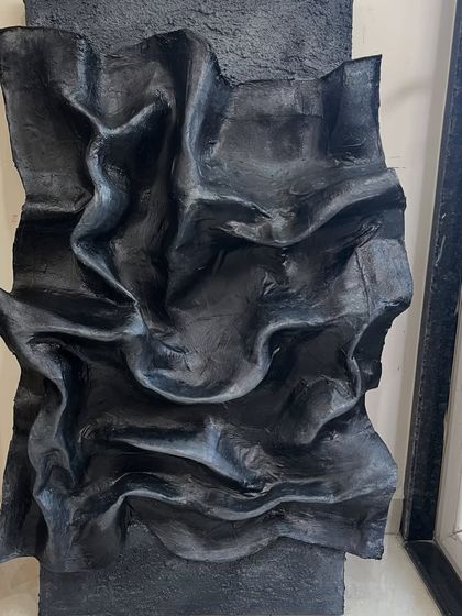 A detailed view of the black sculptural artwork. You can see the intricate folds and waves I created, which took months of patient work to perfect.